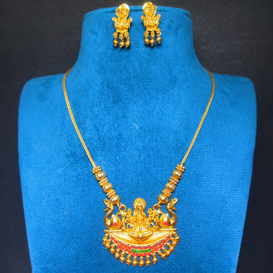 Antique Gold Finish necklace and earrings on a blue mannequin bust against a dark background
