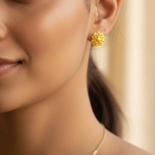 Close-up of a woman wearing gold plated Indian Classic earrings with a blurred background