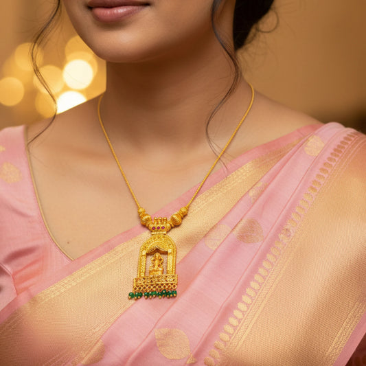 Woman wearing a gold plated necklace with Goddess Lakshmi in a Temple Arch Pendant with a pink saree against a warm background