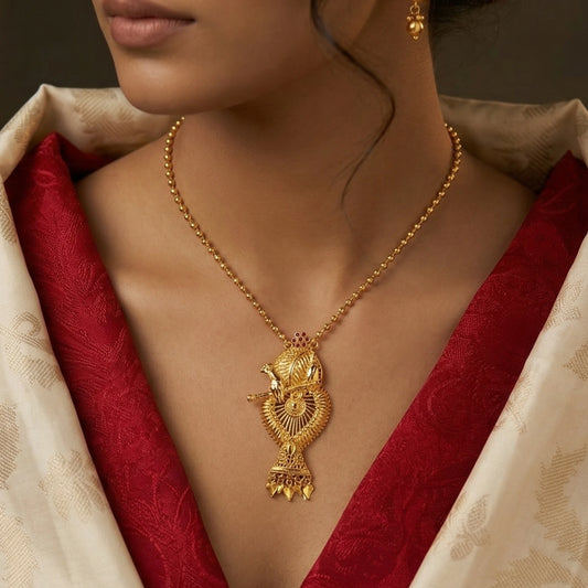 Gold plated necklace with a pendant design with Krishna with Flute worn by a person in a red and beige traditional outfit.