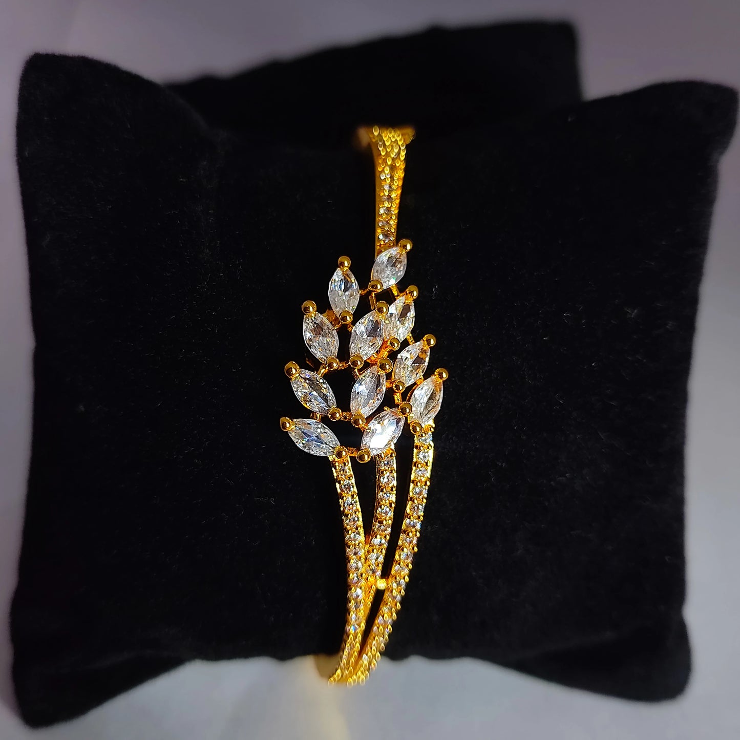 Gold plated AD Cuff on a black cushion
