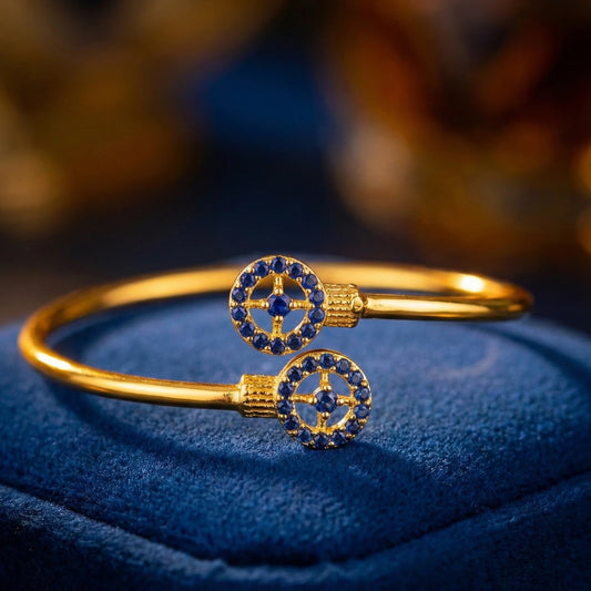 Gold plated bracelet with blue stones on a blue cushion