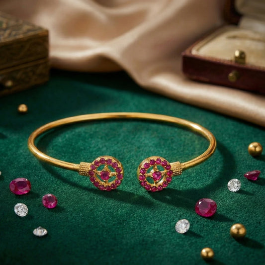 Gold plated bracelet with pink gemstones on a green fabric background