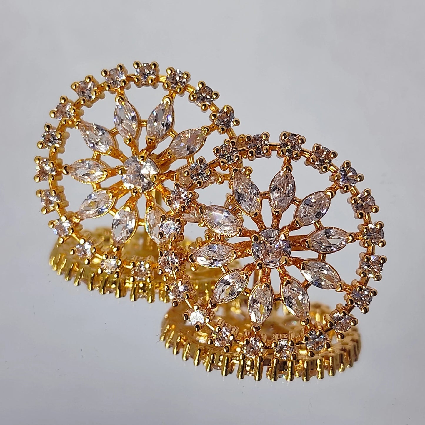 Gold plated marquise crystal floral stud earrings on a gray background