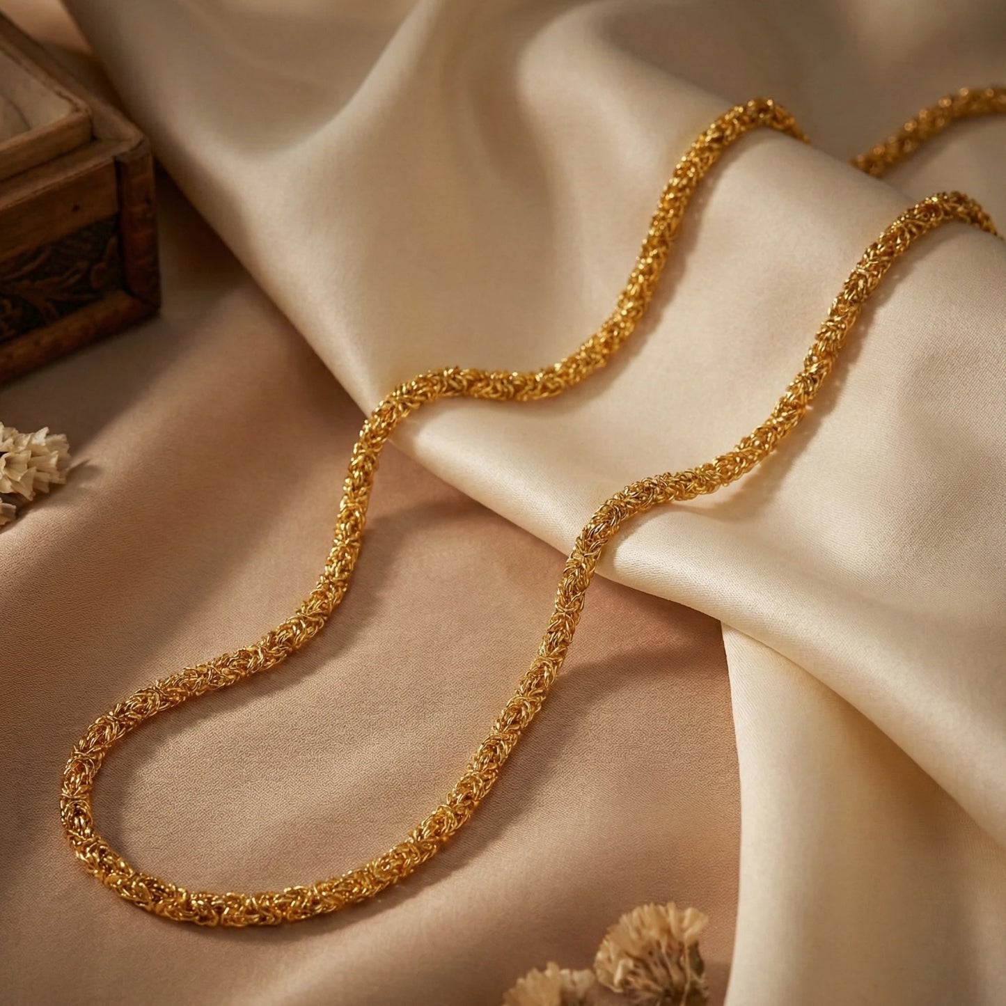 Gold plated neckchain on a beige fabric background