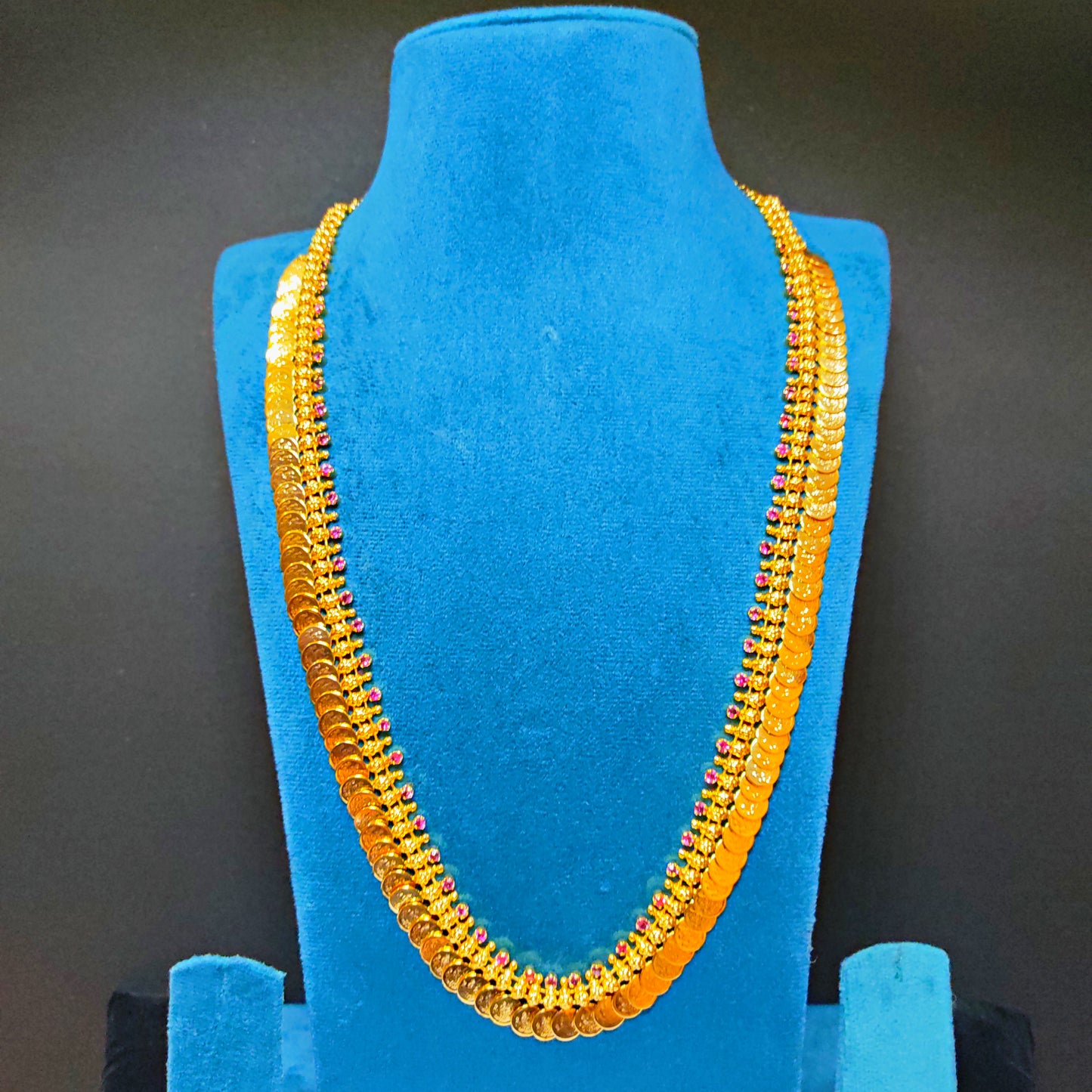 Gold Plated Kasu Mala on a blue mannequin bust against a dark background