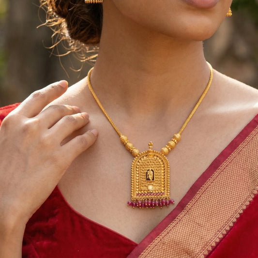 Woman wearing a gold plated traditional Krishna Temple Arch Pendant necklace with a red saree