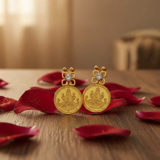 Gold plated Lakshmi Coin earrings with intricate designs on red rose petals on a wooden surface.
