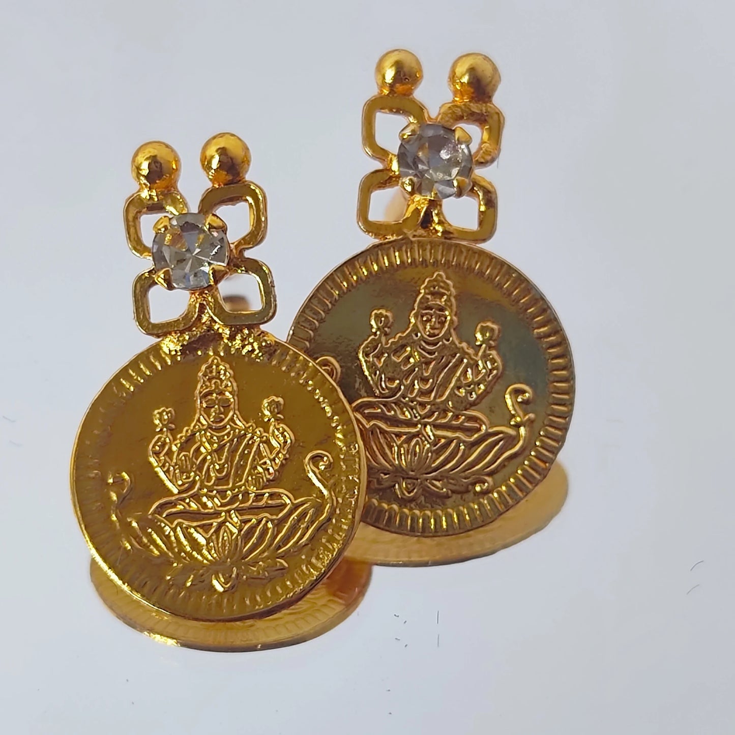 Pair of gold plated Lakshmi Coin earrings on a white background