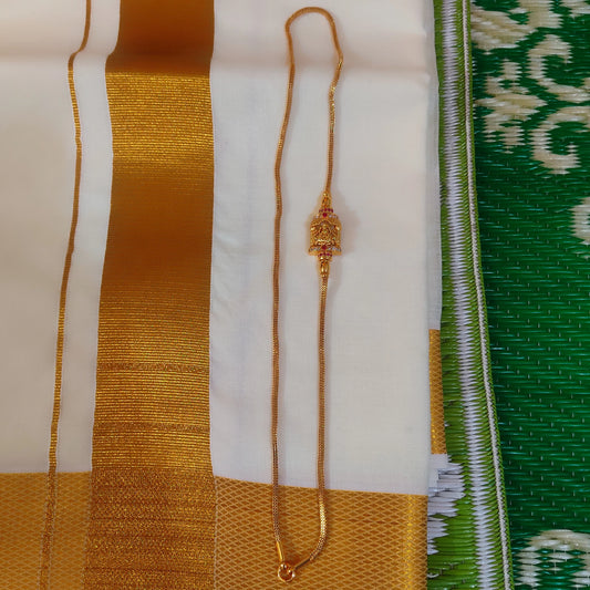 Gold plated Mugappu chain with lakshmi motif on a fabric background with green, white, and gold patterns