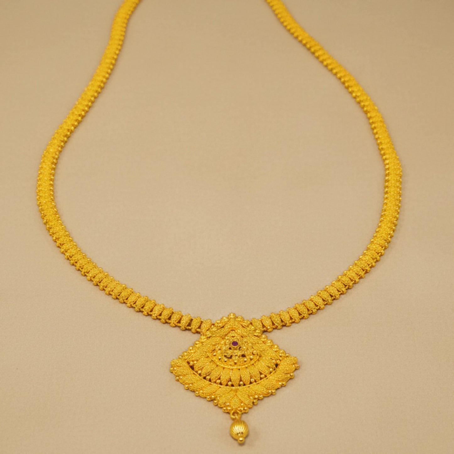 Gold Plated Long Haram necklace with a decorative pendant on a beige background