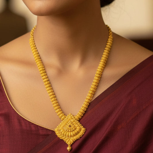 Gold plated Long Haram necklace on a person wearing a maroon saree