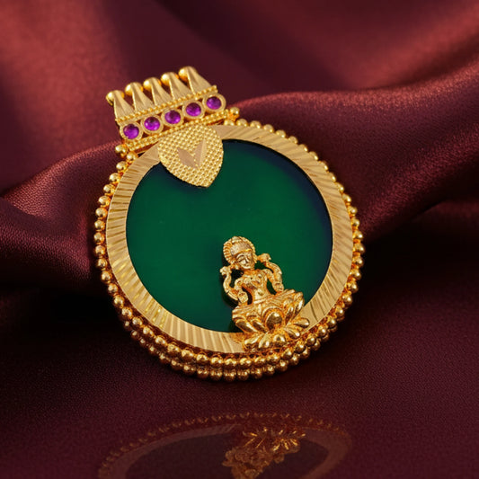 Gold plated pendant with green stone and pink gemstones on a red fabric background