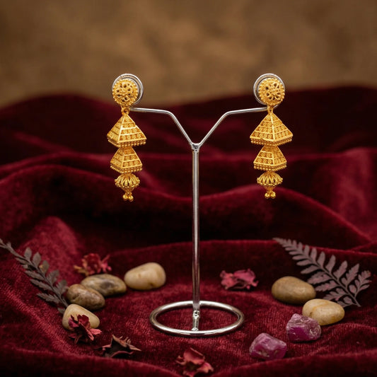 Gold plated 3 tier Jimikki/Jhumka earrings on a stand with a red fabric background