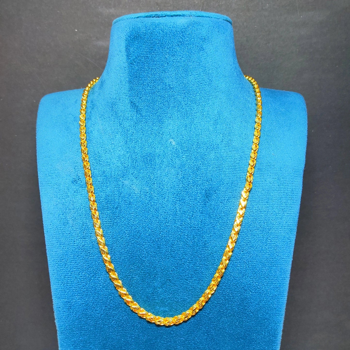 Gold plated neck chain with wheat link pattern on a blue mannequin bust