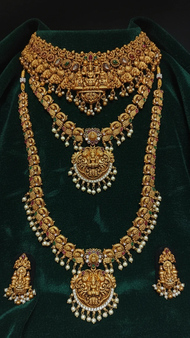 Antique Gold Finish jewelry set with necklaces, earrings, and Choker on a green velvet background