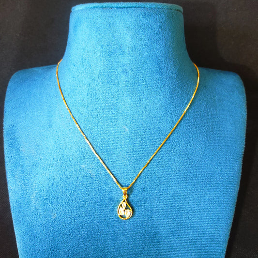 Gold plated neckchain with a pendant on a blue mannequin bust against a black background