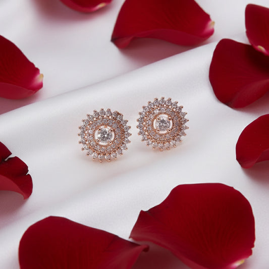 Rose gold earrings with clear gemstones on red rose petals
