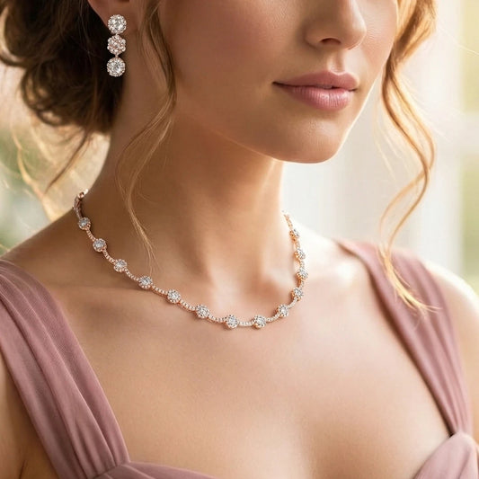 Close-up of a woman wearing a Rose Gold necklace and earrings with a blurred background