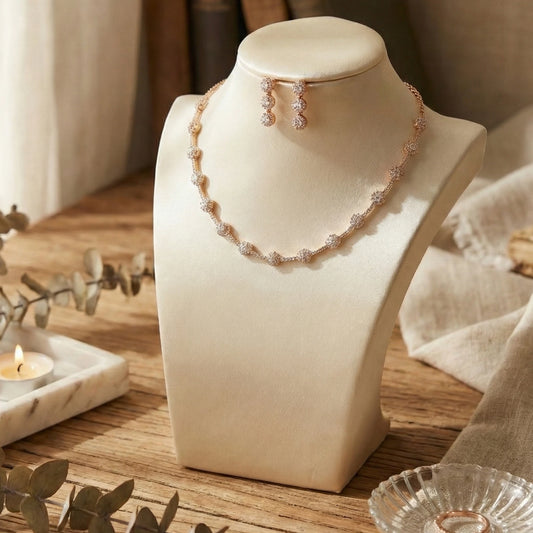 Rose Gold Necklace and earrings on a mannequin bust with a soft-focus background