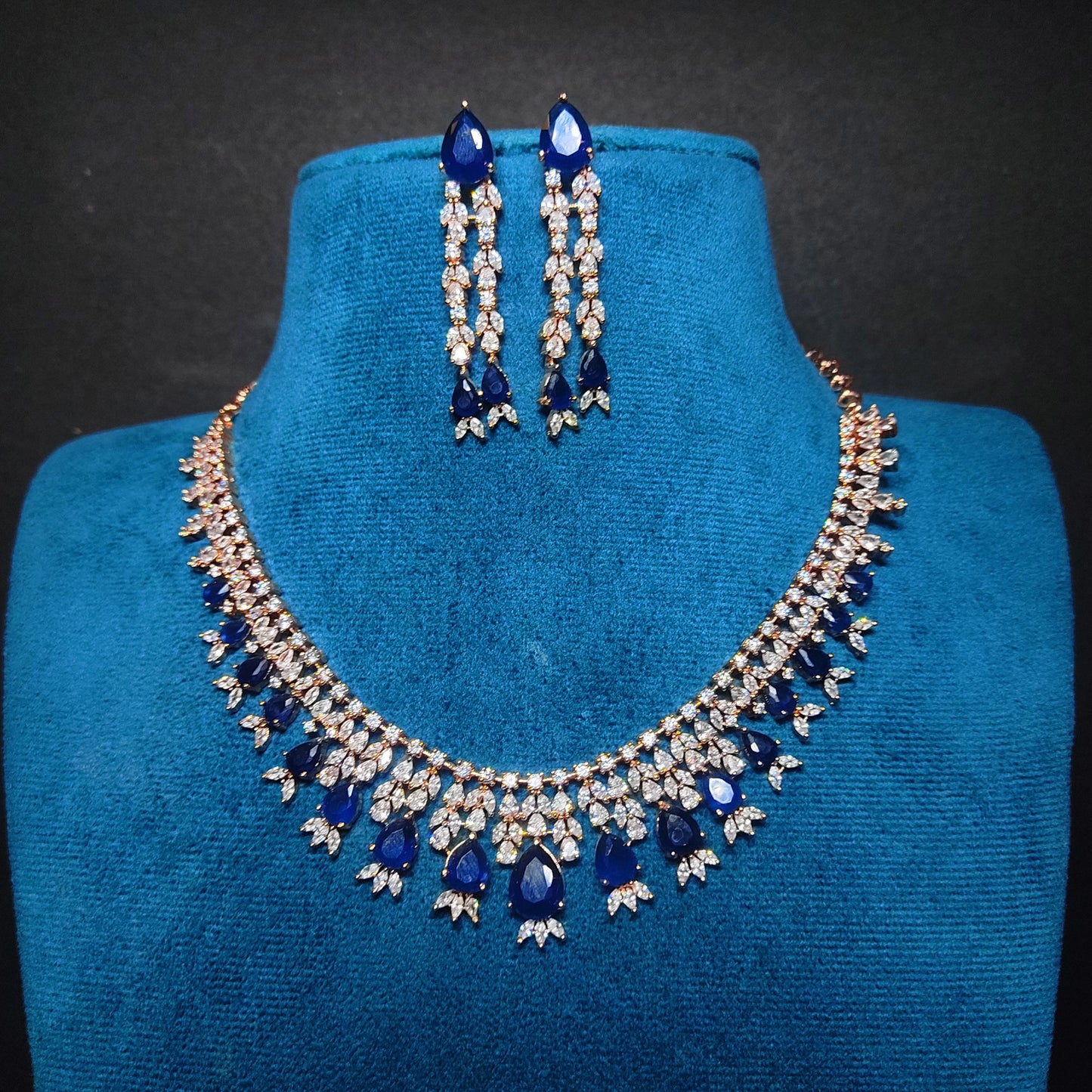 Rose Gold Jewelry set with necklace and earrings on a blue mannequin bust