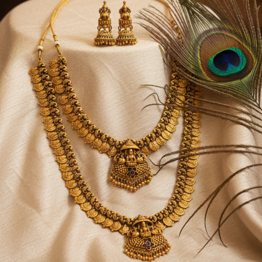a multi-layered Lakshmi motif antique gold finish temple jewelry set on a beige background with a peacock feather