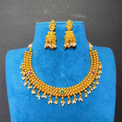 Gold-toned traditional beaded necklace and matching earrings displayed on a blue jewelry bust against a dark gray background.