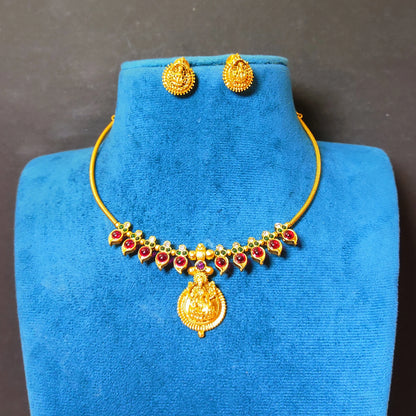 matte antique gold finish Hasli choker necklace featuring alternating pink and green cabochon stones and a central Goddess Lakshmi pendant with matching earrings.