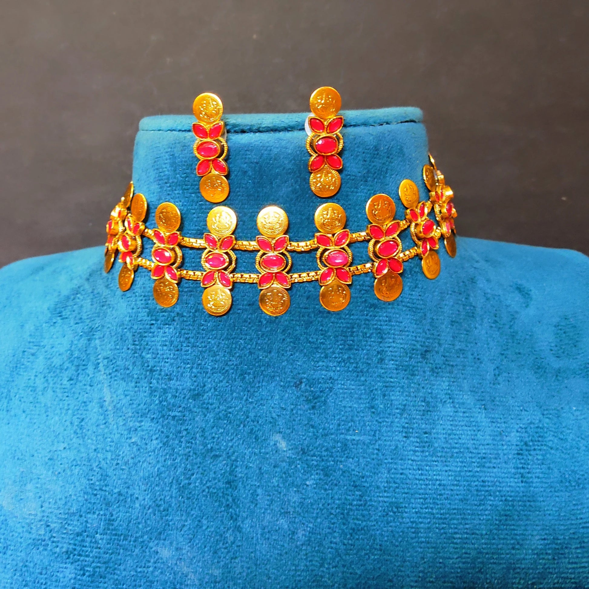 Traditional South Indian matte gold Kasu Mala coin choker necklace with ruby stone accents and matching stud earrings,