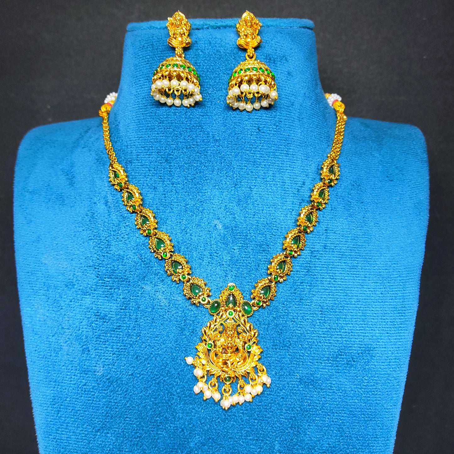 antique gold finish lakshmi pendant necklace with green stones in mannequin