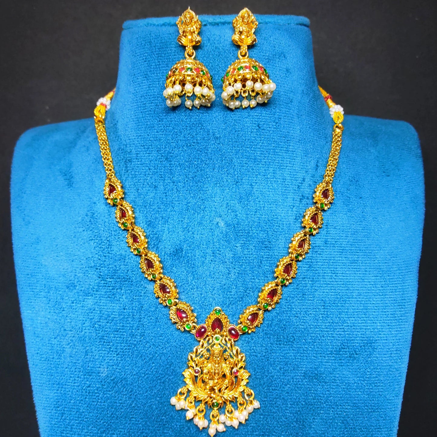 antique gold finish lakshmi pendant necklace with multicolor stones in a mannequin