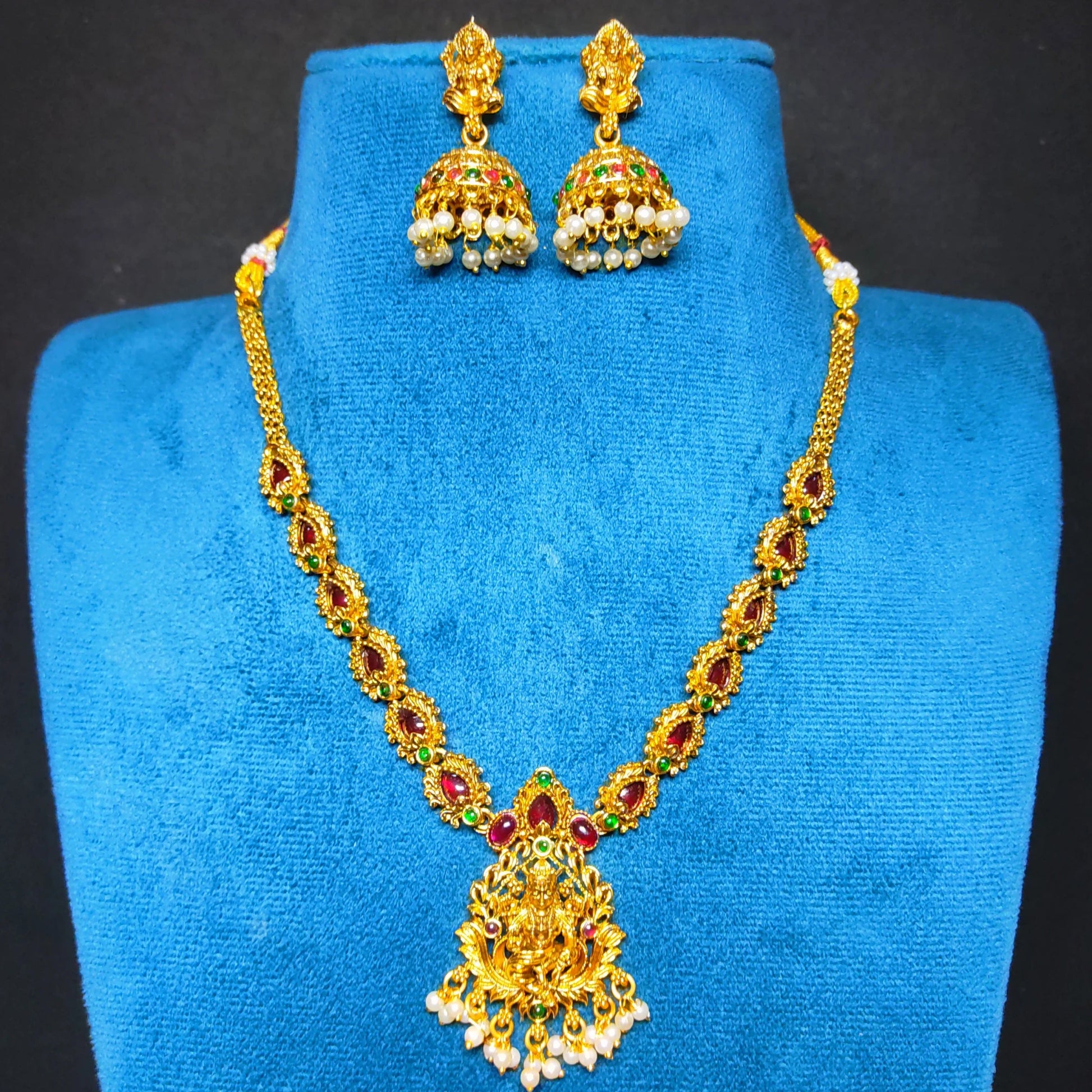antique gold finish lakshmi pendant necklace with multicolor stones in a mannequin