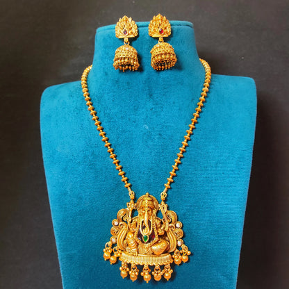 Traditional Indian matte antique gold temple necklace featuring a Lord Ganesha pendant and matching Jhumka earrings on a blue mannequin