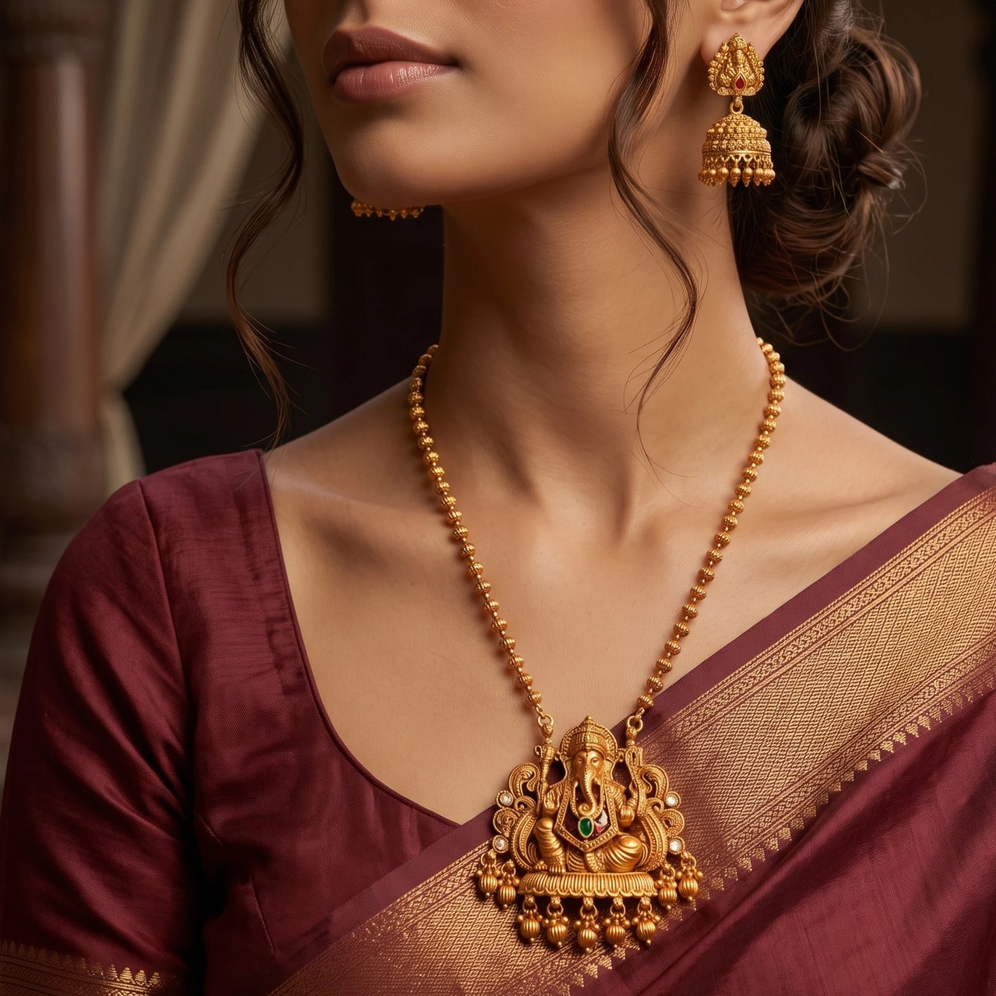 Model wearing Traditional Indian matte antique gold temple necklace featuring a Lord Ganesha pendant and matching Jhumka earrings .