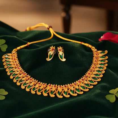 Antique Gold Finish Mango necklace and earrings set on a green fabric background