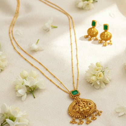 Antique Gold Finish necklace with green gemstones and matching earrings on a white floral background