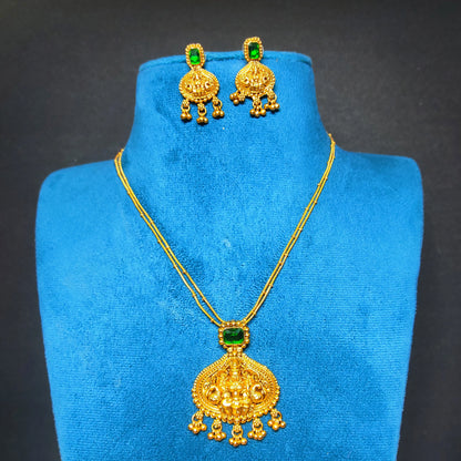 Antique Gold Finish necklace and earrings with green gemstones on a blue mannequin bust against a dark background
