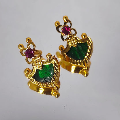 Pair of gold plated earrings with green palakka and ruby red gemstones on a white background