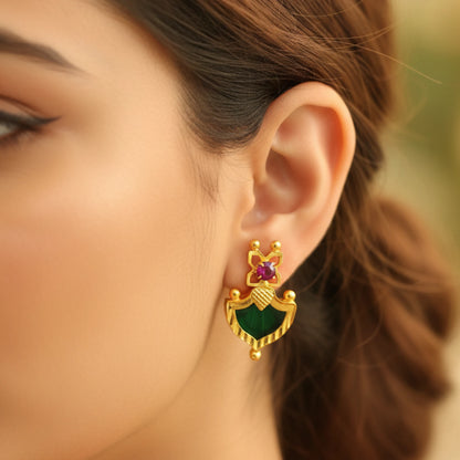 Gold plated earring with green palakka and ruby red gemstone worn by a person