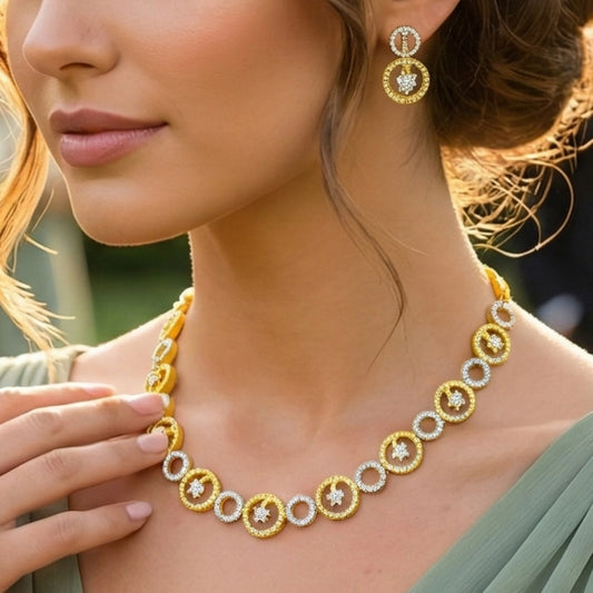 Close-up of a woman wearing a gold toned necklace and earrings.