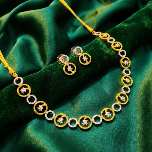 Gold tone and Chromium circular jewelry set on a green fabric background
