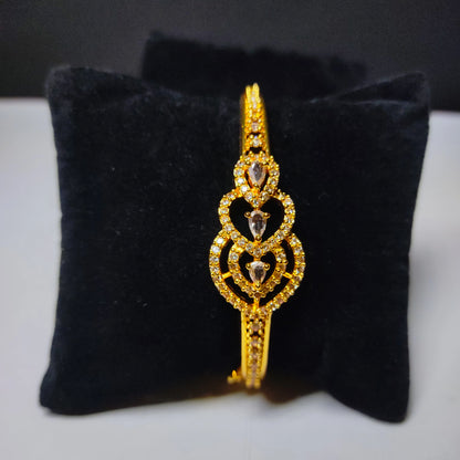 Gold plated bracelet with diamond accents on a black velvet cushion