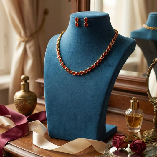 AD Red Necklace and earrings on a blue mannequin bust with a perfume bottle and roses in the background.