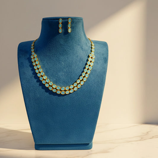  jewelry mannequin with a Gold-Plated Necklace and earrings with Blue Stone on a neutral background