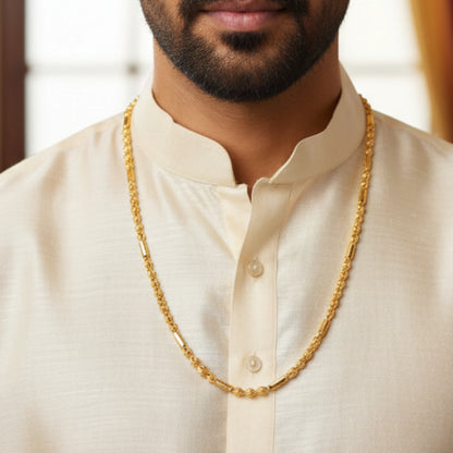 Man wearing a gold plated neck chain with beads and cylindrical pattern with a blurred background
