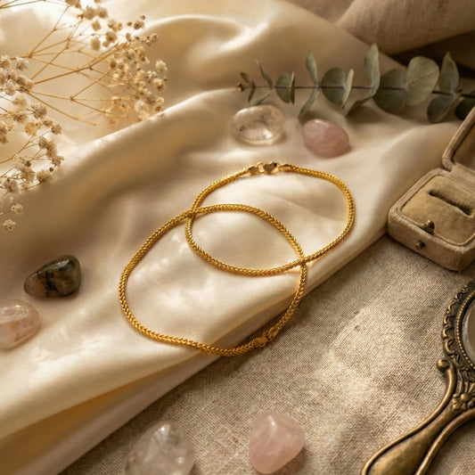 Gold plated Anklets on a textured surface with crystals and flowers