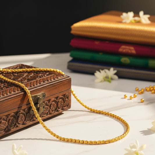 Wooden jewelry box with gold plated chain on a white surface with sarees in the background