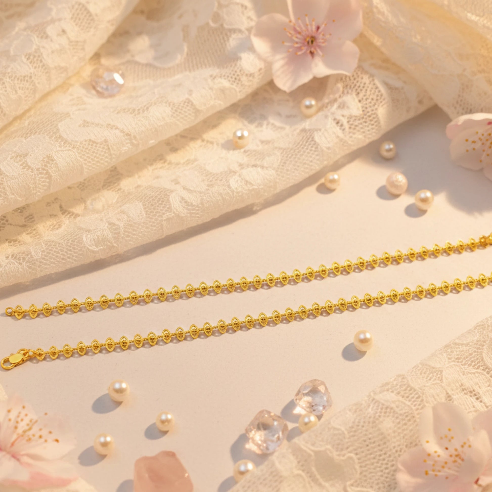 Gold plated delicate lace design anklets on a lace fabric background with pearls and flowers