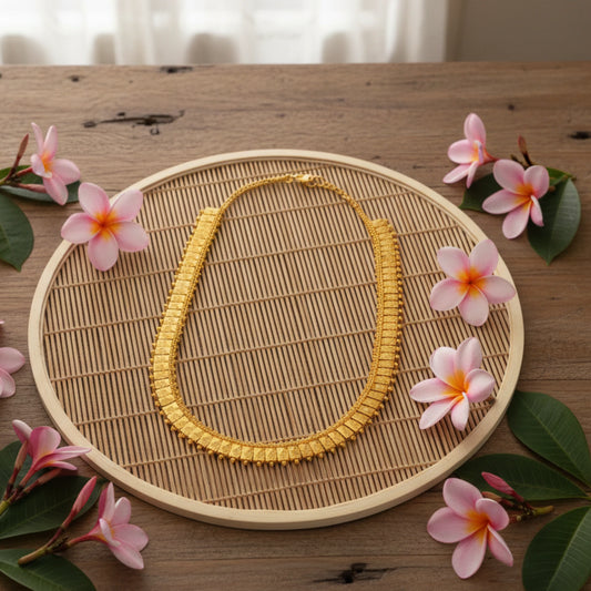 Gold plated Lakshmi Square Coin haram necklace on a wooden board with pink flowers