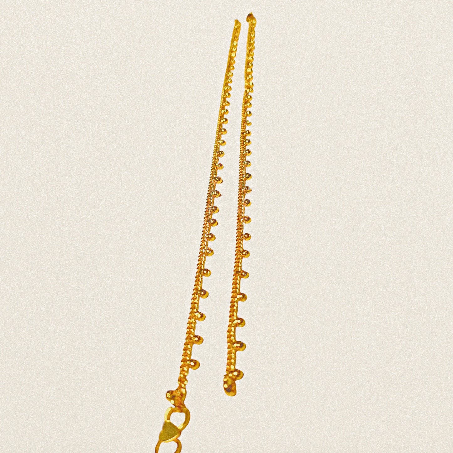 Gold plated Anklets on a beige background